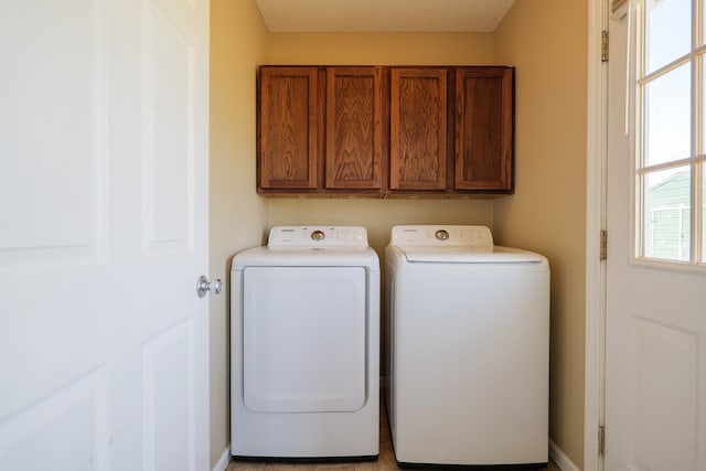 washroom with cabinet space and washer and clothes dryer