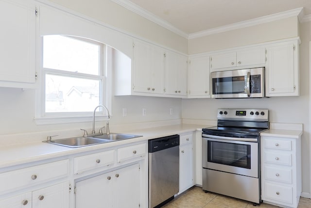 kitchen with appliances with stainless steel finishes, a sink, white cabinetry, and crown molding