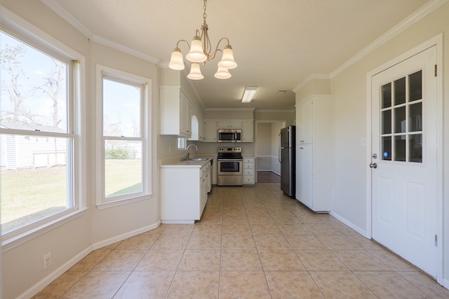 kitchen with light tile patterned floors, ornamental molding, stainless steel appliances, light countertops, and a sink