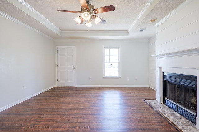 unfurnished living room featuring a raised ceiling, a fireplace with flush hearth, ornamental molding, wood finished floors, and a textured ceiling