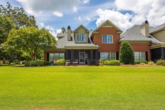 4059 Live Oaks Cir, Valdosta, GA 31601 - back of property with a sunroom, a yard, brick siding, and roof with shingles