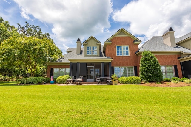4059 Live Oaks Cir, Valdosta, GA 31601 - back of property with a sunroom, a yard, brick siding, and a shingled roof