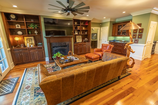 4059 Live Oaks Cir, Valdosta, GA 31601 - living area featuring ceiling fan, light wood-style floors, ornamental molding, a wainscoted wall, and a high end fireplace