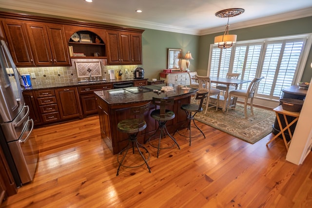 4059 Live Oaks Cir, Valdosta, GA 31601 - kitchen featuring stainless steel fridge with ice dispenser, a kitchen breakfast bar, backsplash, a center island, and light wood-style flooring