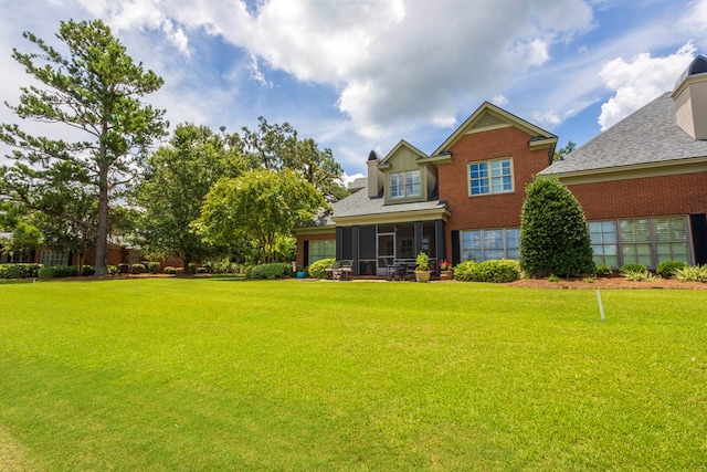 4059 Live Oaks Cir, Valdosta, GA 31601 - rear view of house featuring a sunroom, a lawn, brick siding, and a shingled roof