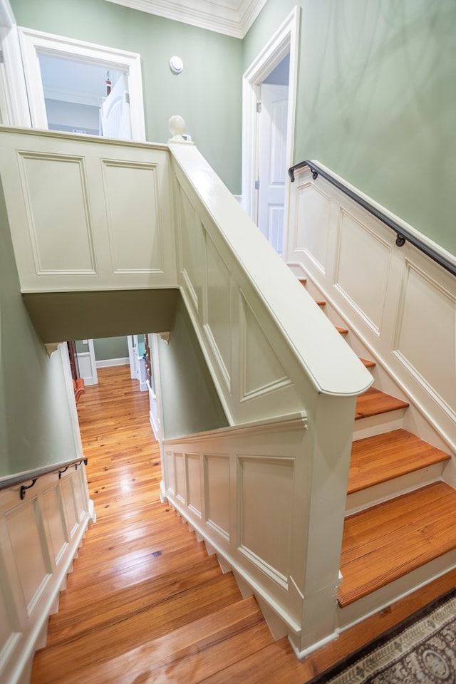 4059 Live Oaks Cir, Valdosta, GA 31601 - stairway featuring a decorative wall, crown molding, wood finished floors, and wainscoting