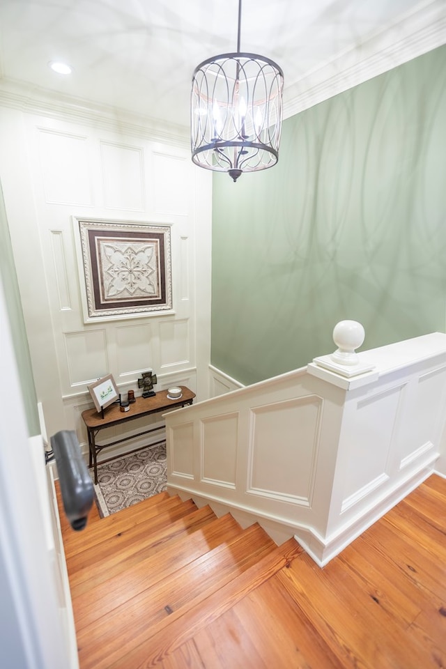 4059 Live Oaks Cir, Valdosta, GA 31601 - stairs featuring a decorative wall, a chandelier, wood finished floors, and ornamental molding