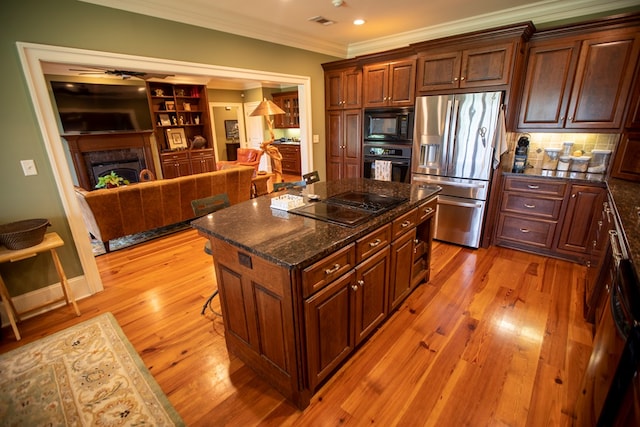 4059 Live Oaks Cir, Valdosta, GA 31601 - kitchen with black appliances, crown molding, light wood finished floors, ceiling fan, and a premium fireplace
