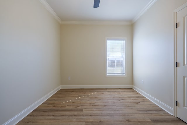 spare room with baseboards, ornamental molding, a ceiling fan, and light wood-style floors