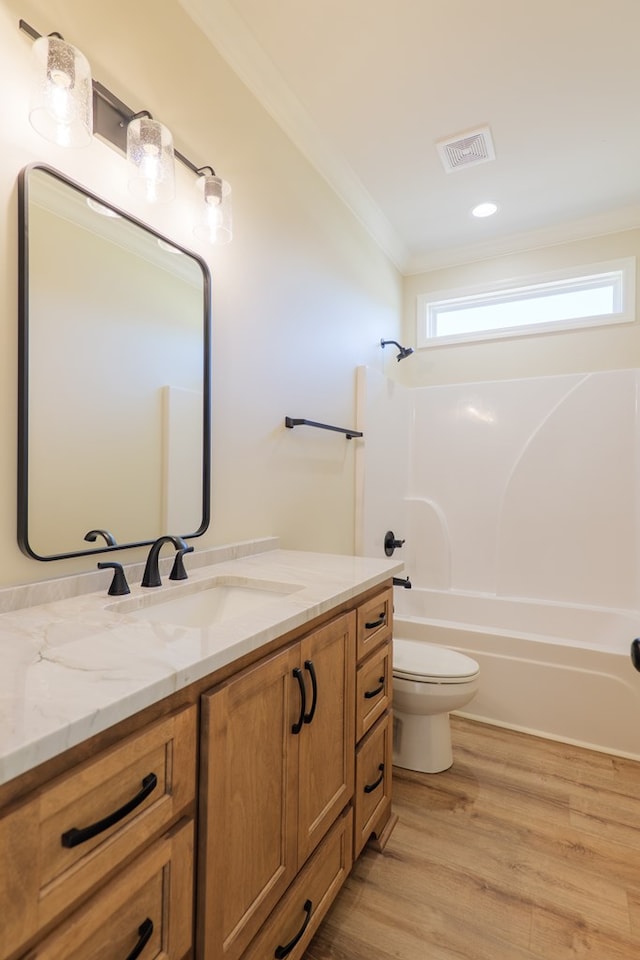 bathroom featuring toilet, vanity, visible vents,  shower combination, and ornamental molding