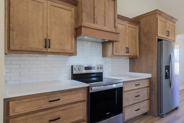 kitchen with custom exhaust hood, stainless steel appliances, backsplash, and light countertops