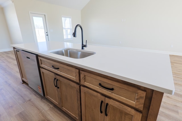 kitchen with stainless steel dishwasher, light wood-style flooring, and a sink