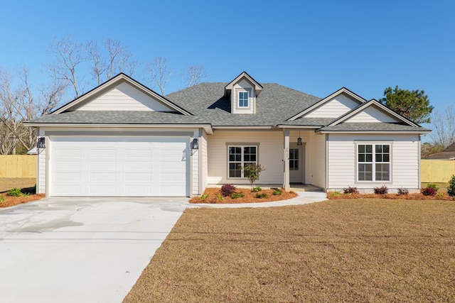 view of front of home with driveway, a front lawn, an attached garage, and a shingled roof