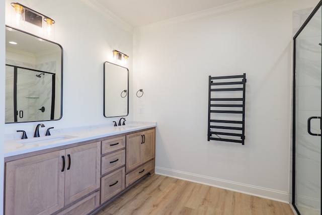 bathroom with radiator heating unit, crown molding, a sink, and wood finished floors