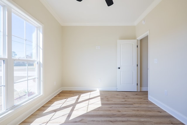 empty room featuring light wood-style floors, baseboards, and ornamental molding