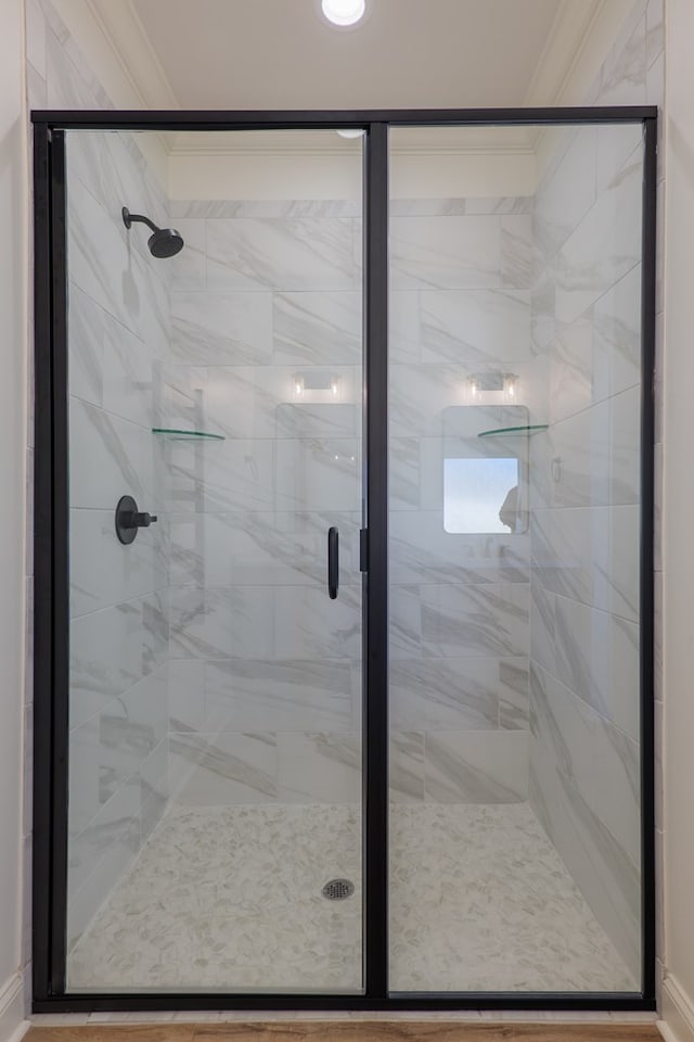 bathroom with ornamental molding and a stall shower