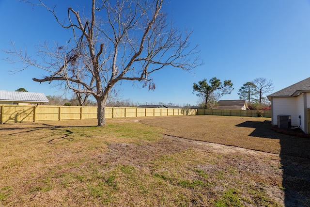 view of yard with central AC unit and a fenced backyard