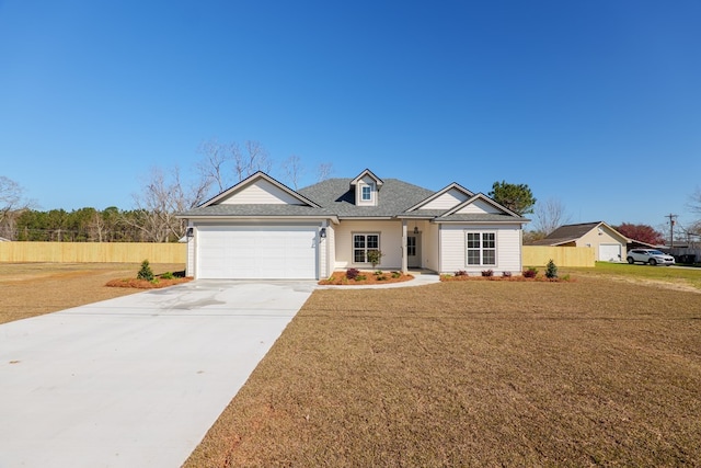 view of front of home with a garage, concrete driveway, a front yard, and fence