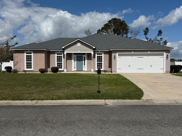 view of front of house with a front yard, a garage, driveway, and stucco siding