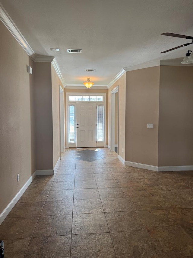 entrance foyer featuring visible vents, baseboards, and crown molding