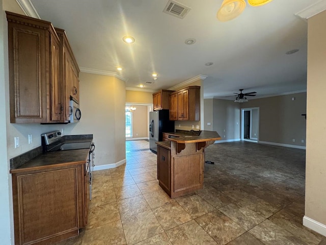 kitchen with a breakfast bar area, visible vents, stainless steel appliances, dark countertops, and ceiling fan with notable chandelier