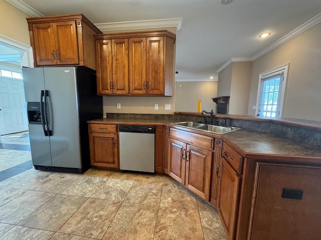 kitchen featuring dark countertops, a peninsula, appliances with stainless steel finishes, and a sink