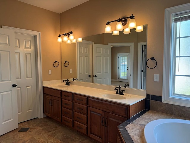 bathroom featuring a sink, a healthy amount of sunlight, and double vanity