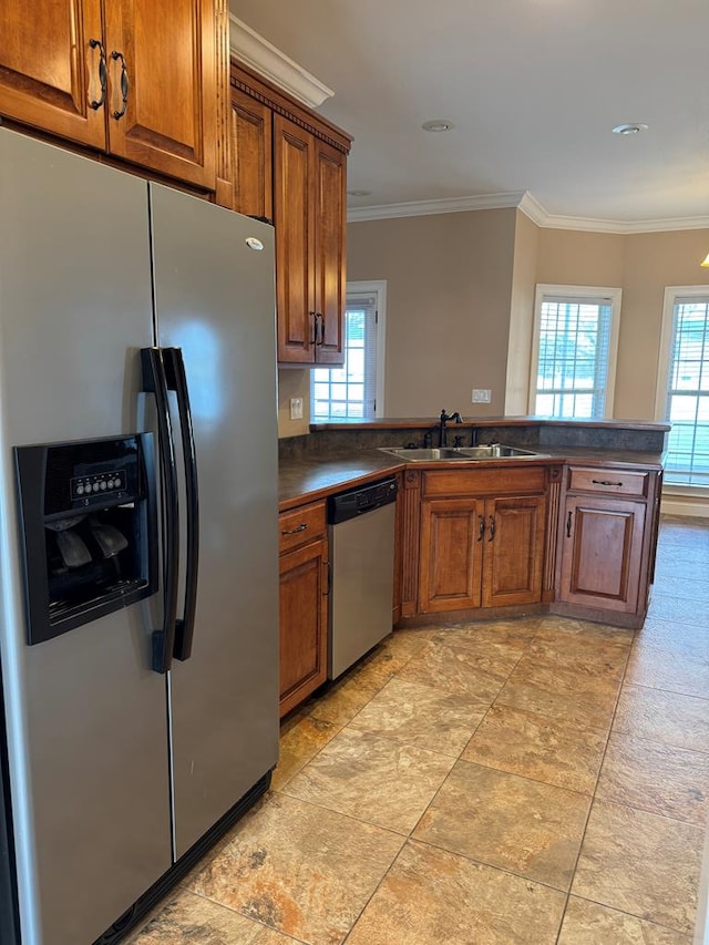 kitchen with a sink, plenty of natural light, dark countertops, and appliances with stainless steel finishes