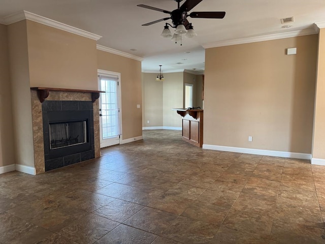 unfurnished living room with a tiled fireplace, crown molding, baseboards, and ceiling fan