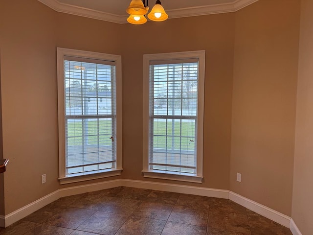 spare room featuring baseboards, a chandelier, and ornamental molding