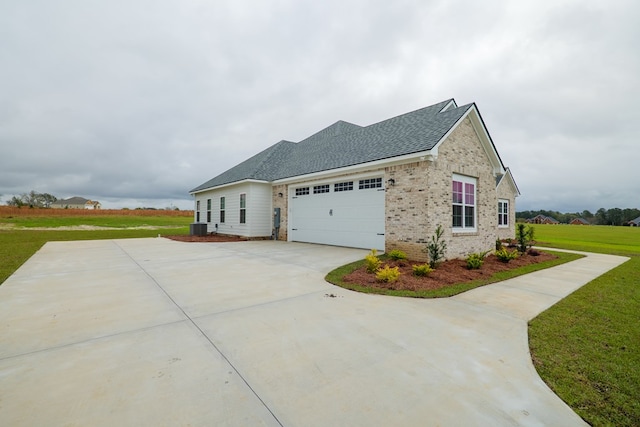 view of home's exterior with a garage, a yard, and central air condition unit