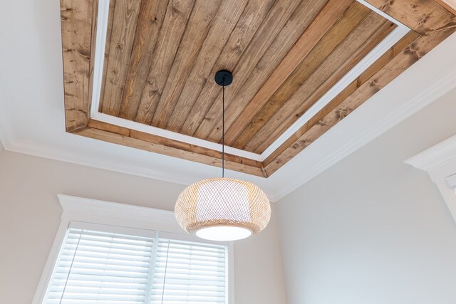 interior details with a tray ceiling, wooden ceiling, and ornamental molding