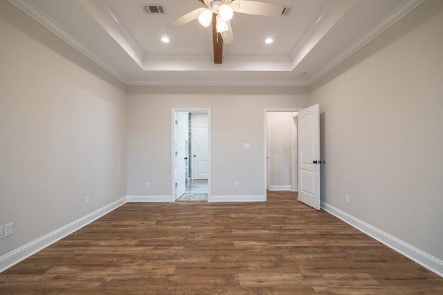 unfurnished bedroom with a raised ceiling, ceiling fan, dark hardwood / wood-style flooring, and crown molding