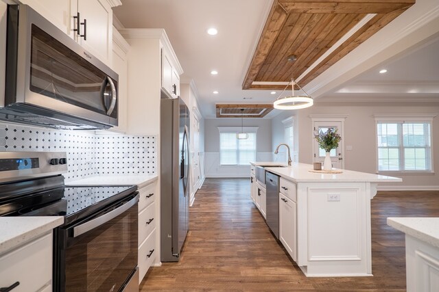 kitchen with stainless steel appliances, dark hardwood / wood-style flooring, decorative light fixtures, a center island with sink, and white cabinets