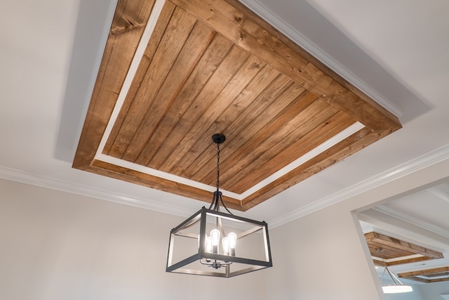 room details featuring a raised ceiling, crown molding, a chandelier, and wooden ceiling