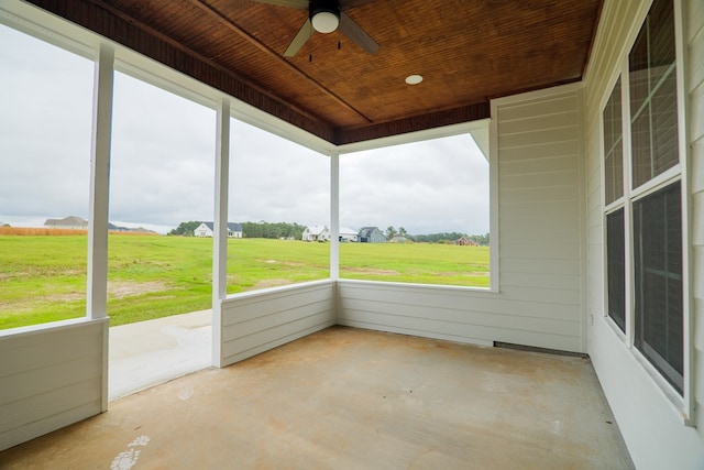 unfurnished sunroom featuring a rural view, a wealth of natural light, and wooden ceiling