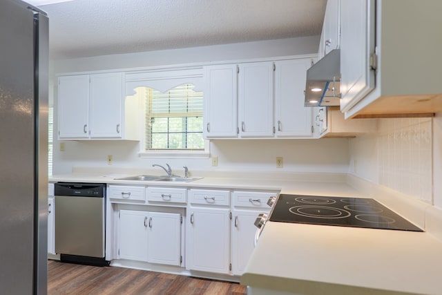 kitchen with a sink, stainless steel appliances, island exhaust hood, dark wood-type flooring, and white cabinetry