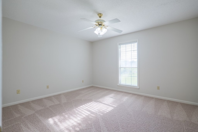 spare room with ceiling fan, carpet flooring, and baseboards