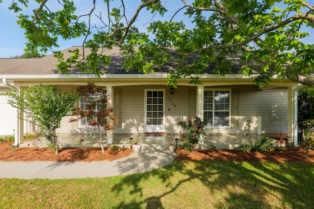 view of front of property with a porch, a front lawn, and roof with shingles