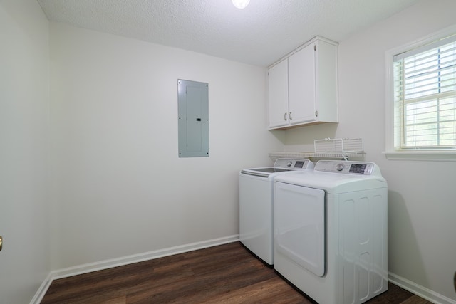 washroom with washing machine and clothes dryer, electric panel, baseboards, dark wood-style flooring, and cabinet space