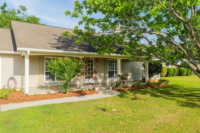 ranch-style house with a front yard, a shingled roof, and covered porch