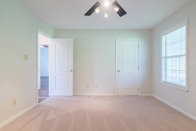 unfurnished room featuring baseboards, ceiling fan, a healthy amount of sunlight, and carpet
