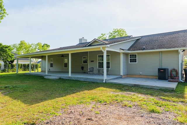 rear view of property with a chimney, a yard, ceiling fan, a patio, and central AC