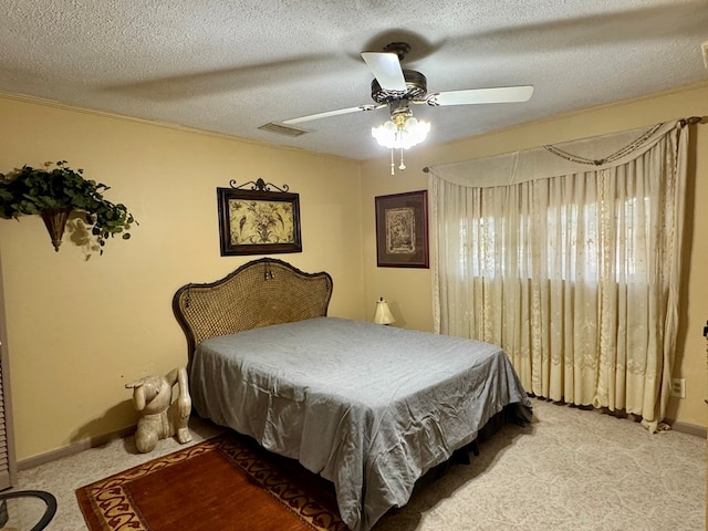 bedroom with ceiling fan, light colored carpet, and a textured ceiling