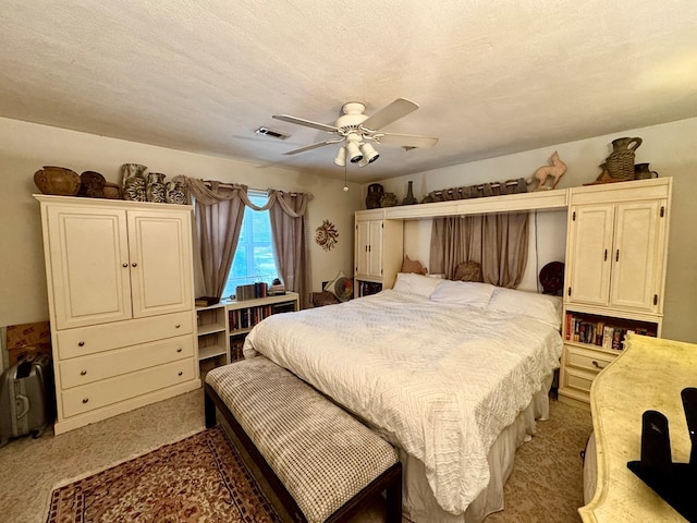 carpeted bedroom with ceiling fan and a textured ceiling