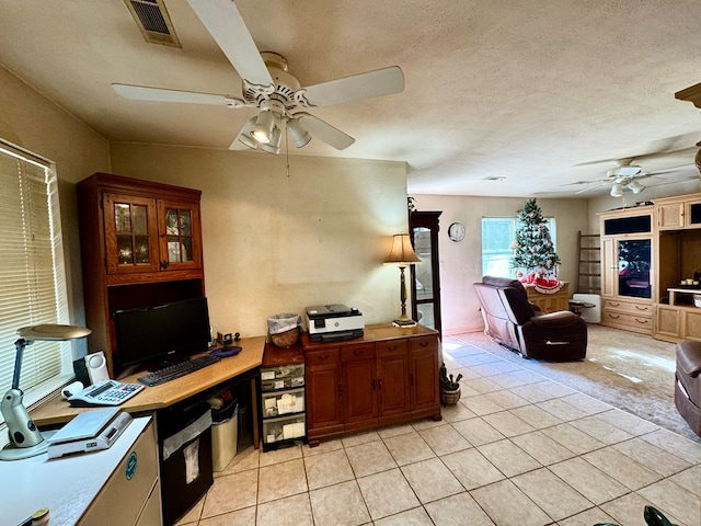 office space with light tile patterned floors, a textured ceiling, and ceiling fan