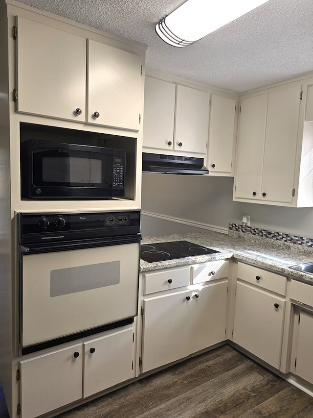 kitchen with dark wood-type flooring, white cabinets, a textured ceiling, and black appliances