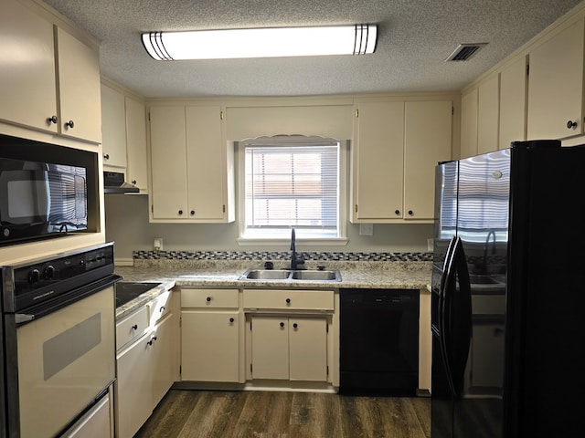 kitchen featuring sink, black appliances, a textured ceiling, dark hardwood / wood-style floors, and cream cabinetry