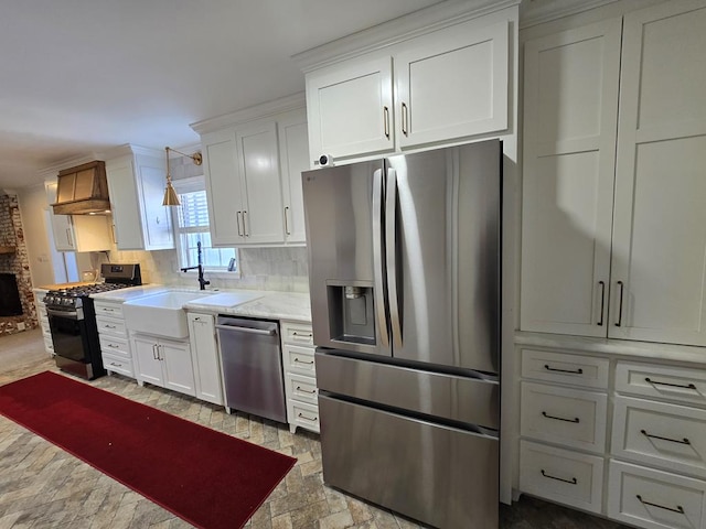 kitchen featuring stainless steel appliances, light countertops, white cabinetry, and custom range hood