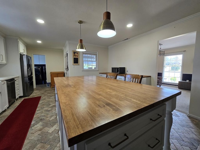 kitchen featuring black fridge, butcher block counters, dishwasher, and washing machine and dryer